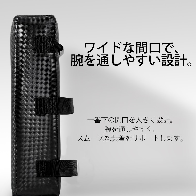 ワイドな間口で、腕を通しやすい設計。一番下の開口を大きく設計。腕を通しやすく、スムーズな装着をサポートします。という説明文。側面のベルトが見える、立てて置かれたキックミット。