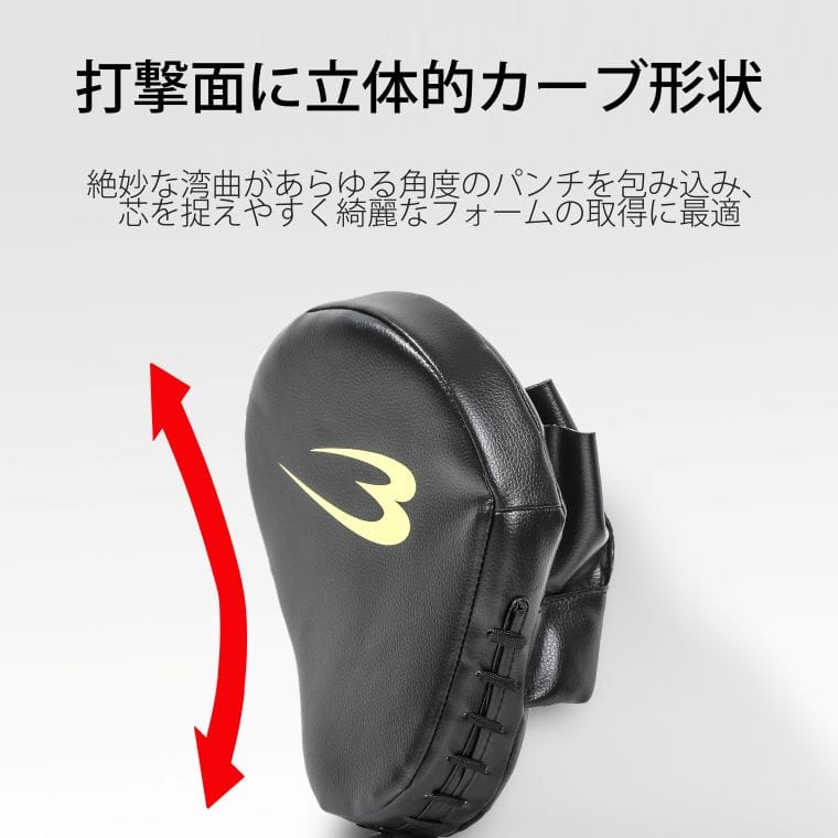 打撃面に立体的カーブ形状。絶妙な湾曲があらゆる角度のパンチを包み込み、芯を捉えやすく綺麗なフォームの習得に最適。湾曲した打撃面を示す赤いカーブ矢印付きのパンチングミット。